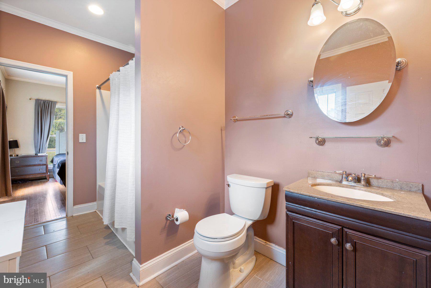 61 Magothy Beach Road Pasadena, MD 21122 - Photo 32 of 63 a bathroom with a sink a mirror a toilet and a shower