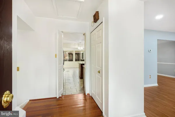 a view of a hallway with wooden floor and cabinet