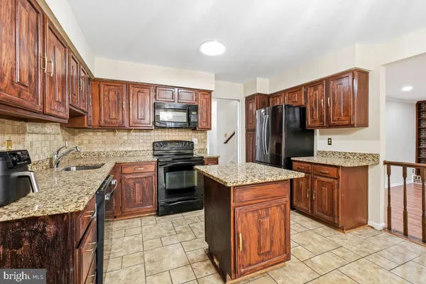a kitchen with stainless steel appliances granite countertop wooden cabinets a stove top oven a sink and dishwasher