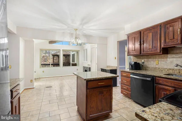 a kitchen with granite countertop a sink stove and cabinets