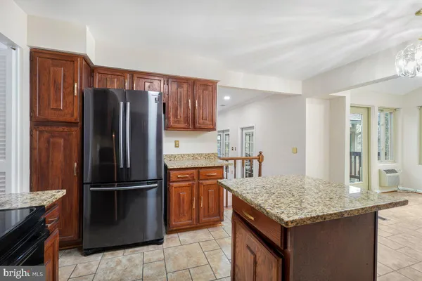 a kitchen with granite countertop stainless steel appliances a refrigerator and a sink