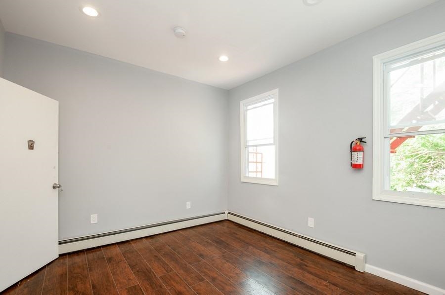 705 8th Street, Unit 2 Union City, NJ 07087 - Photo 11 of 19 an empty room with wooden floor and windows