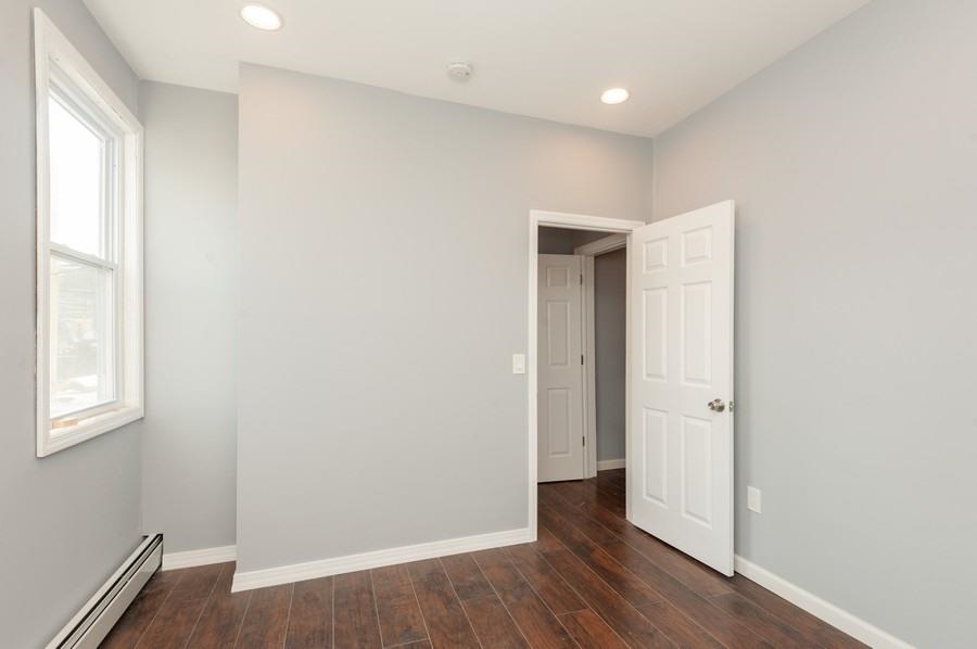 705 8th Street, Unit 2 Union City, NJ 07087 - Photo 17 of 19 an empty room with wooden floor and windows
