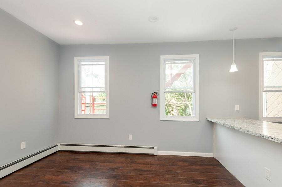 705 8th Street, Unit 2 Union City, NJ 07087 - Photo 9 of 19 an empty room with wooden floor and windows