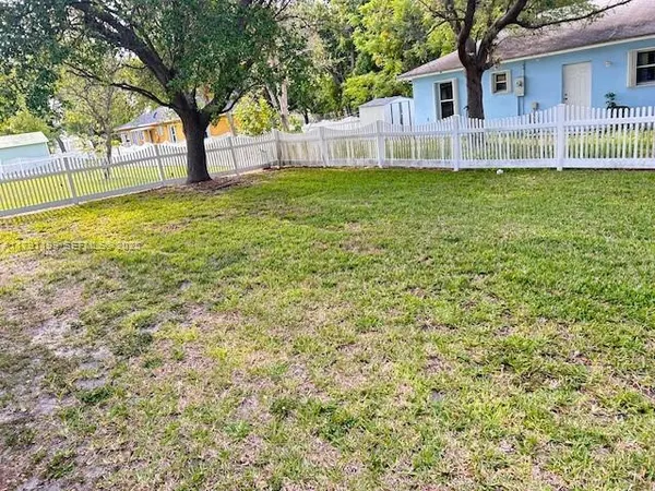 a backyard of a house with lots of green space and fountain