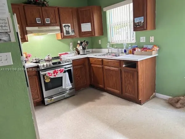 a kitchen with a sink stove and cabinets