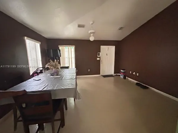 a view of a kitchen with granite countertop a sink and a refrigerator