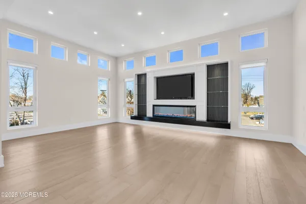 a view of empty room with wooden floor and fireplace