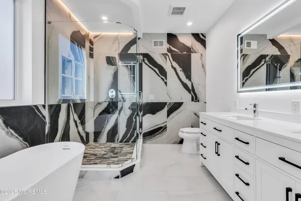 a bathroom with a tub sink and mirror