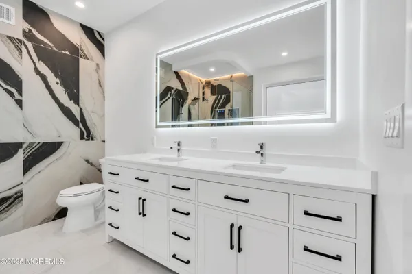 a bathroom with a toilet a sink and mirror