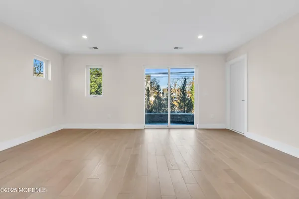 an empty room with window and wooden floor