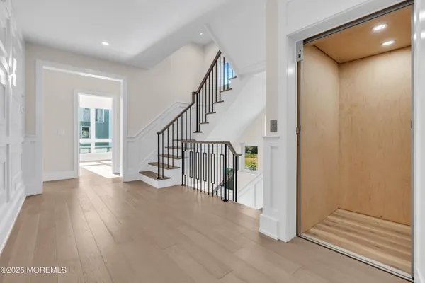 a view of a hallway with wooden floor and entryway