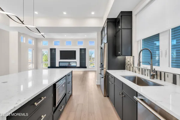 a large kitchen with kitchen island a large counter top space a sink stainless steel appliances and cabinets