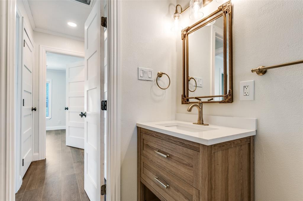 711 Winston Street Dallas, TX 75208 - Photo 6 of 12 Bathroom featuring vanity, dark wood-style flooring, ornamental molding, and recessed lighting