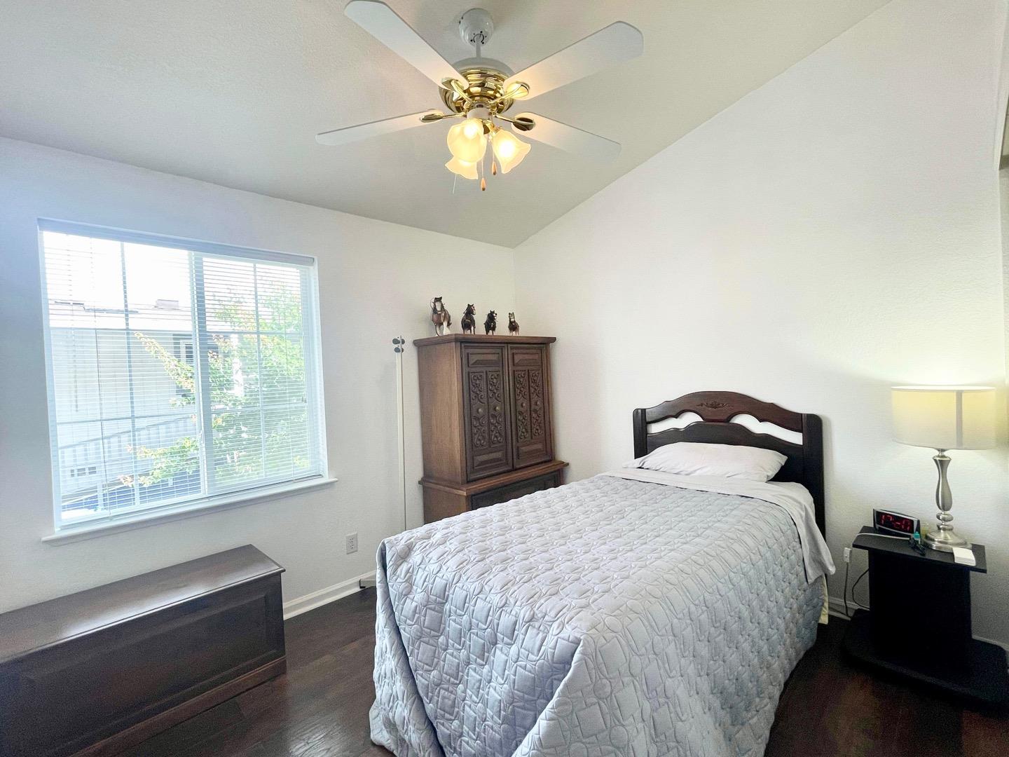 711 Old Canyon Road, Unit 13 Fremont, CA 94536 - Photo 16 of 26 a bed room with a bed and a chandelier