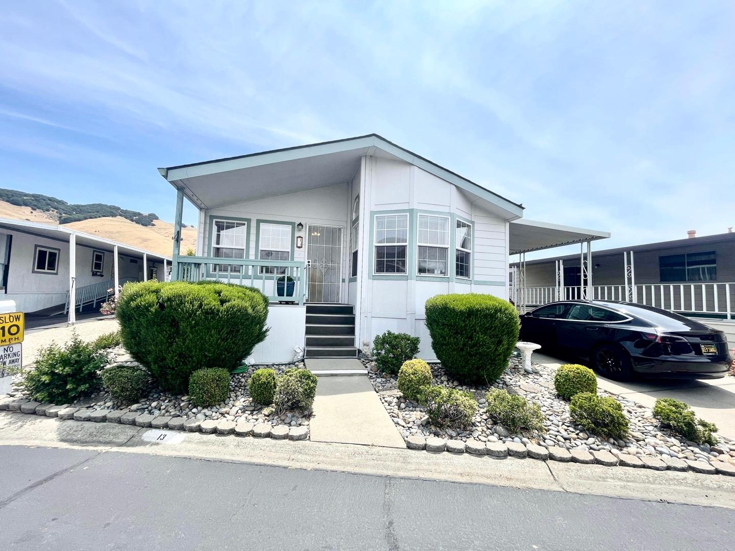 711 Old Canyon Road, Unit 13 Fremont, CA 94536 - Photo 2 of 26 a front view of a house with a garden and plants