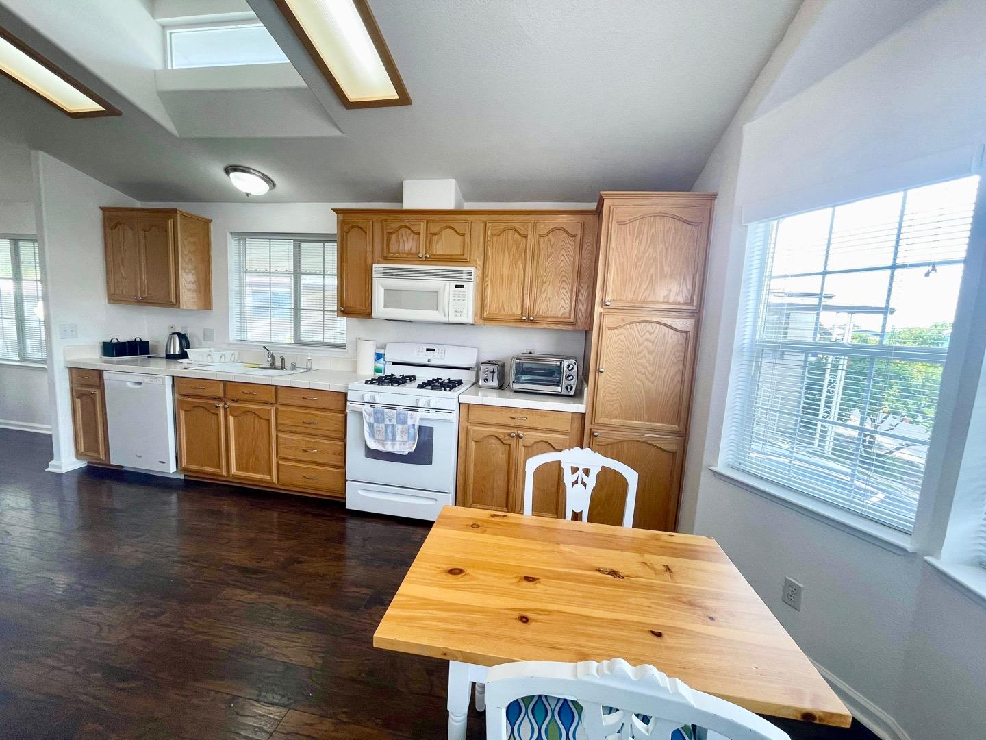 711 Old Canyon Road, Unit 13 Fremont, CA 94536 - Photo 10 of 26 a kitchen with stainless steel appliances granite countertop a stove a sink dishwasher and a refrigerator with wooden floor