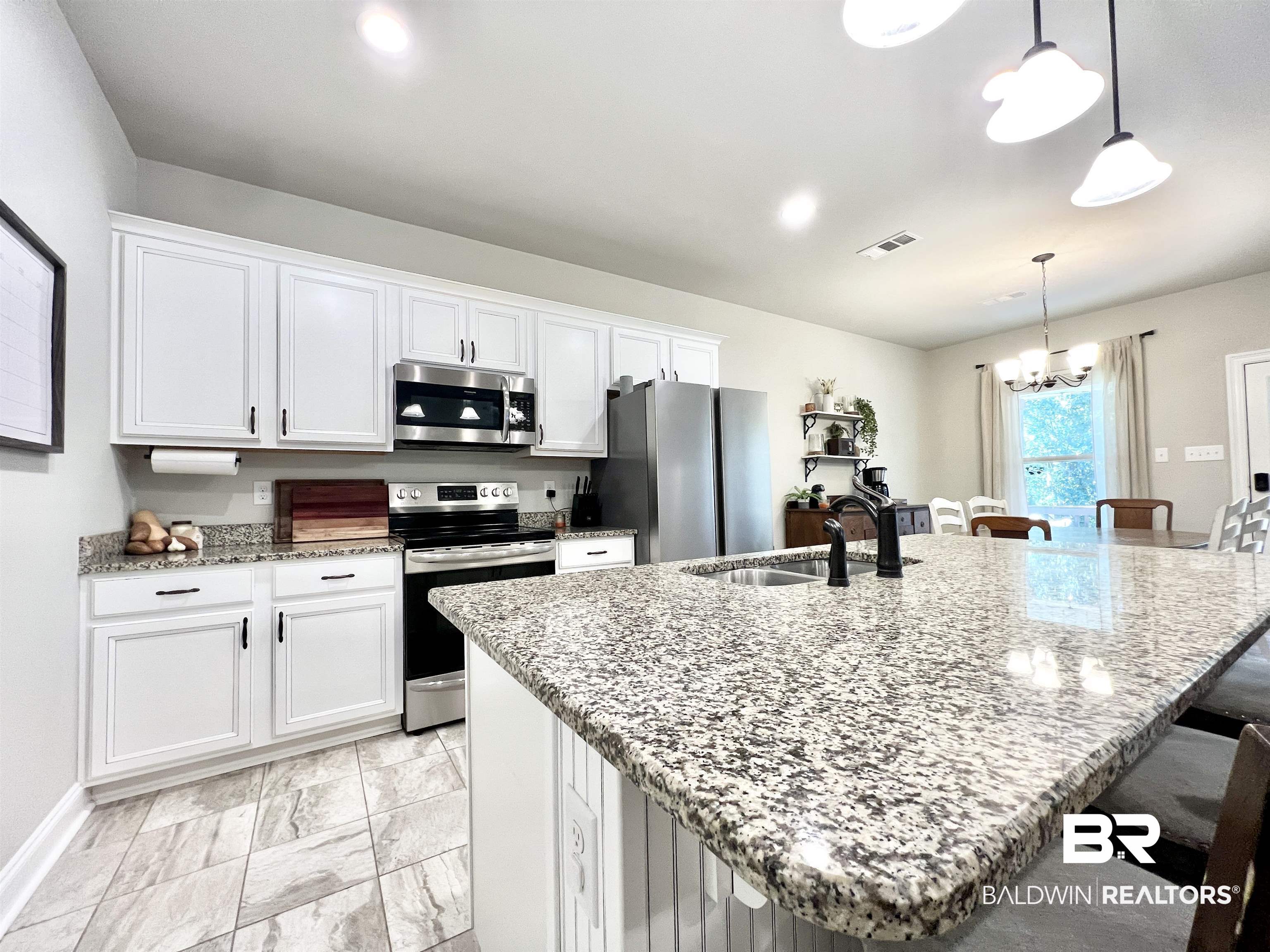 32290 Calder Court Daphne, AL 36527 - Photo 22 of 59 Kitchen with a breakfast bar area, appliances with stainless steel finishes, an island with sink, sink, and decorative light fixtures