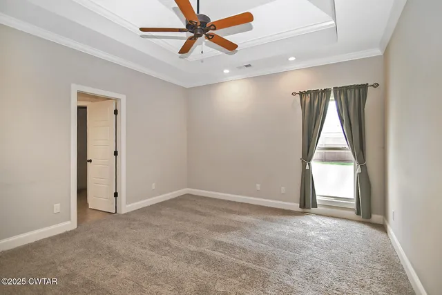an empty room with a window and a ceiling fan