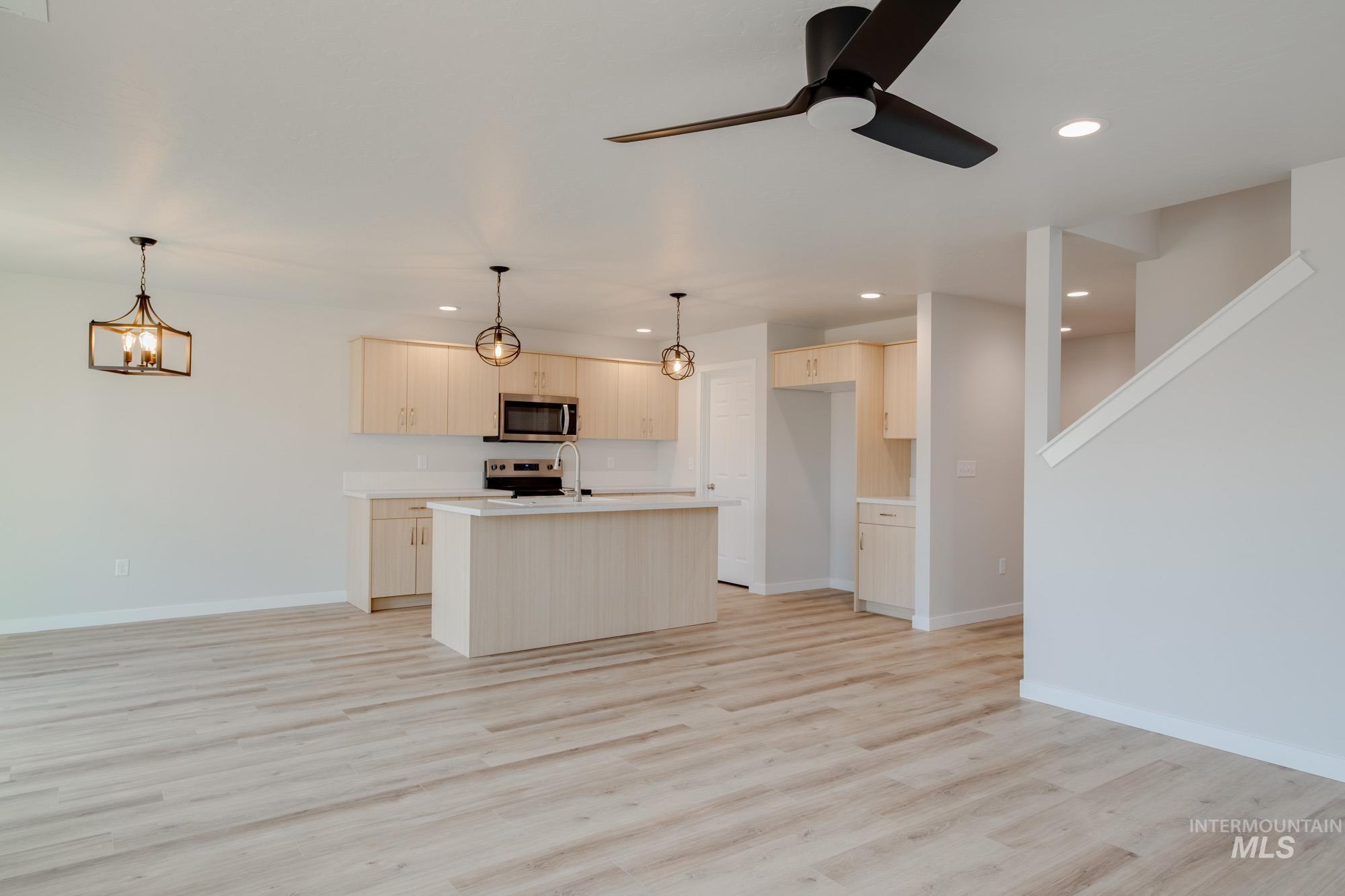 2462 West Fallon Loop Nampa, ID 83651 - Photo 23 of 23 Kitchen with open floor plan, light countertops, a center island with sink, recessed lighting, and pendant lighting