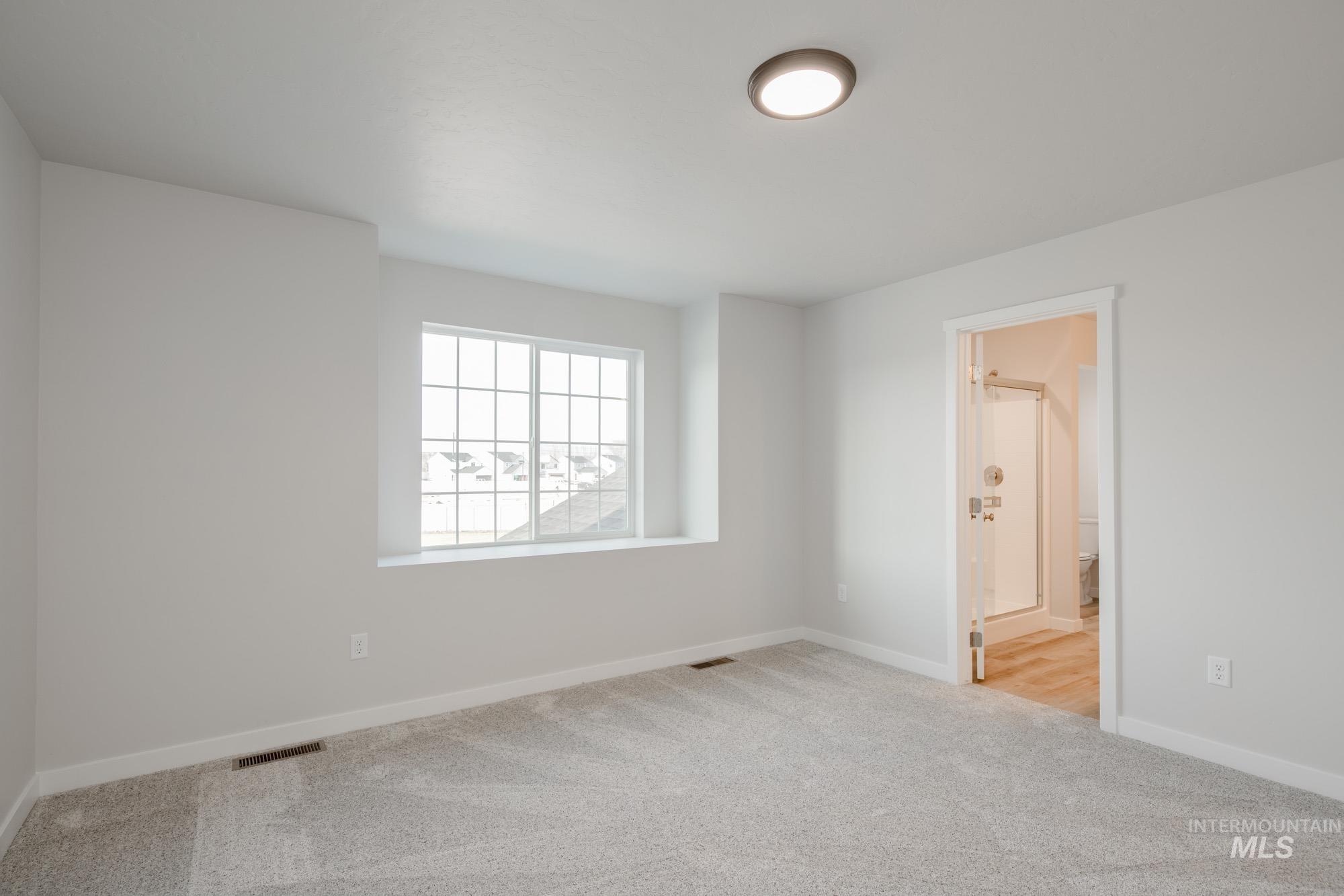 2462 West Fallon Loop Nampa, ID 83651 - Photo 13 of 23 Unfurnished bedroom with light carpet and ensuite bath