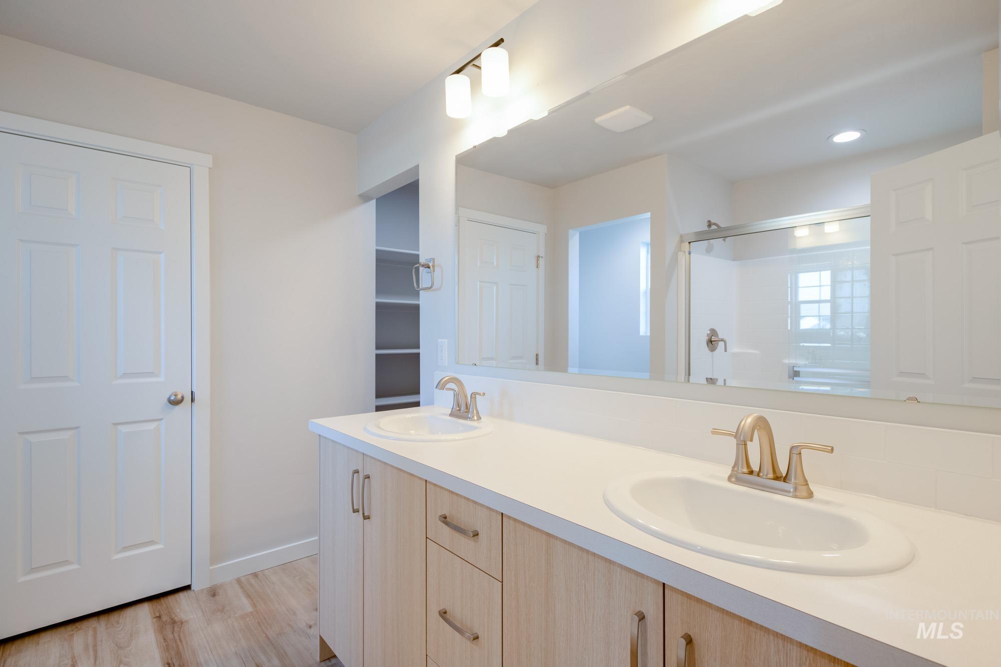 2462 West Fallon Loop Nampa, ID 83651 - Photo 14 of 23 Full bathroom with double vanity, a stall shower, and light wood finished floors