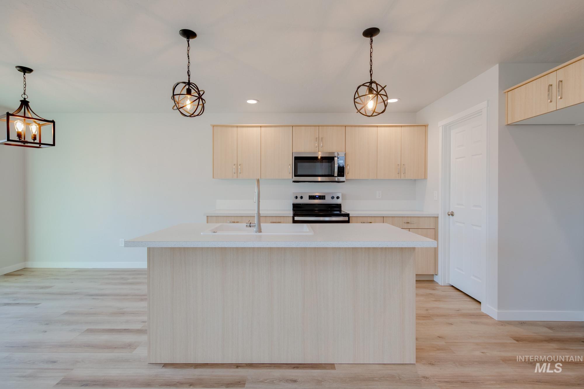2462 West Fallon Loop Nampa, ID 83651 - Photo 3 of 23 Kitchen with light countertops, hanging light fixtures, appliances with stainless steel finishes, light brown cabinetry, and recessed lighting
