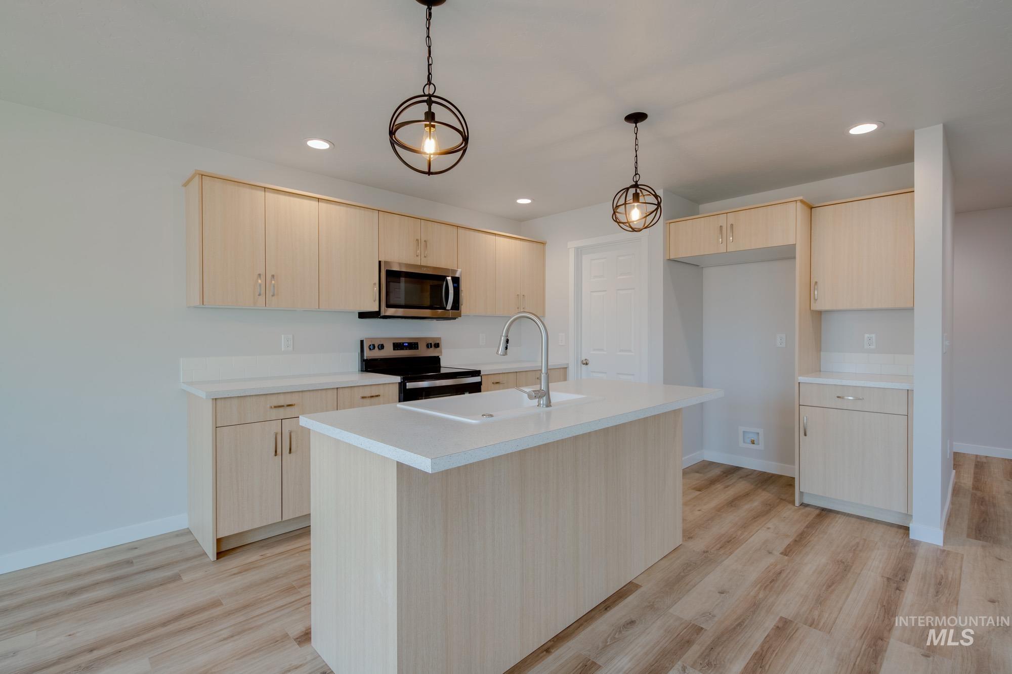 2462 West Fallon Loop Nampa, ID 83651 - Photo 5 of 23 Kitchen featuring light brown cabinets, appliances with stainless steel finishes, light countertops, recessed lighting, and light wood-style floors