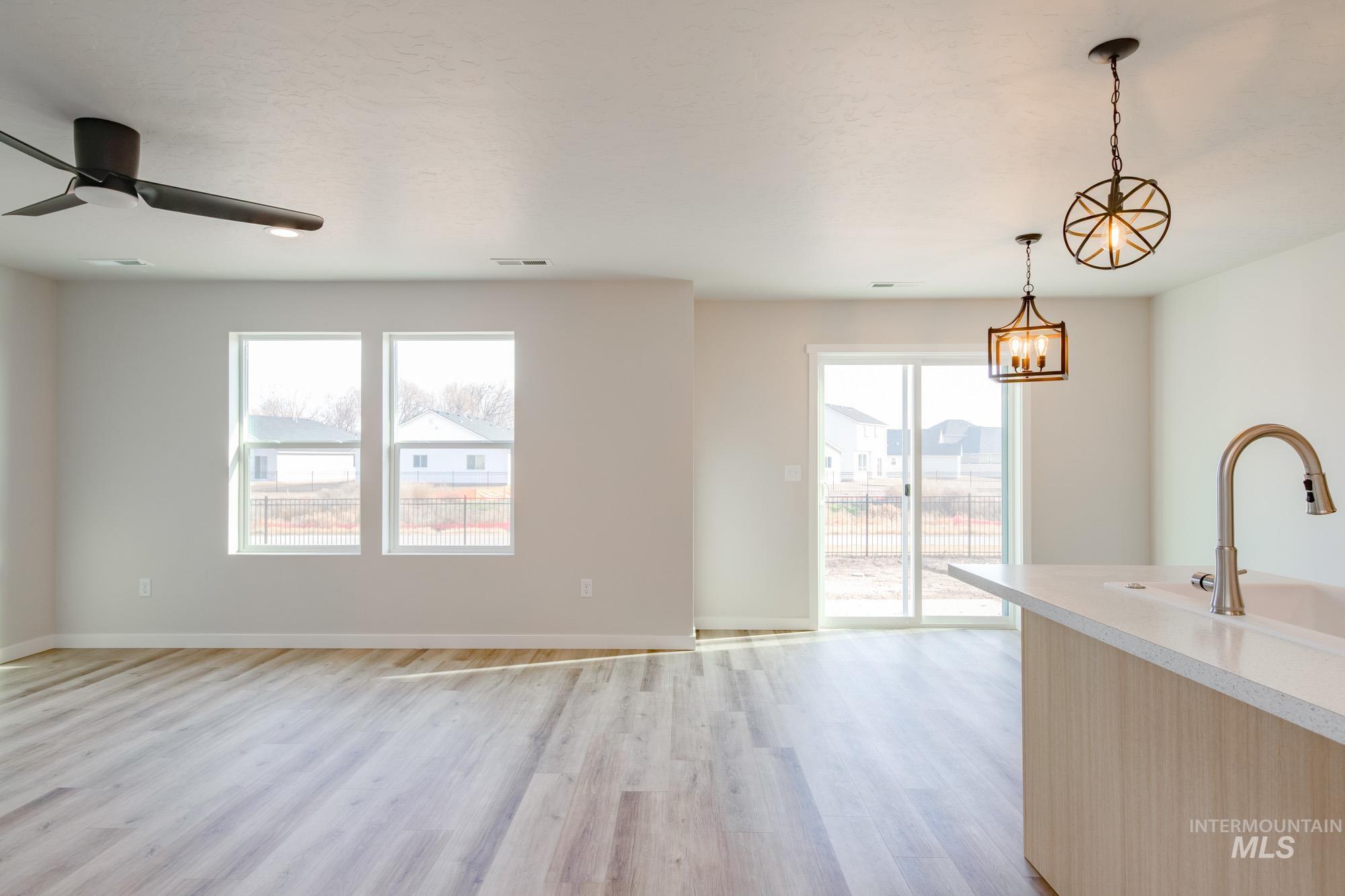 2462 West Fallon Loop Nampa, ID 83651 - Photo 9 of 23 Kitchen featuring hanging light fixtures, light countertops, light wood finished floors, and plenty of natural light