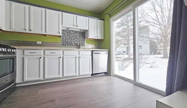 a kitchen with white cabinets and a window