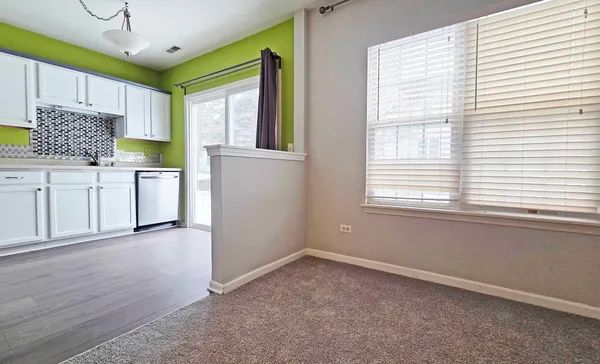 a kitchen with white cabinets and wooden floor
