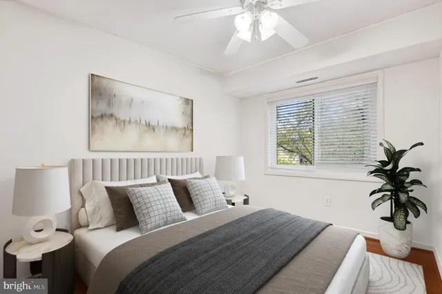 a bedroom with a bed and a painting on the wall