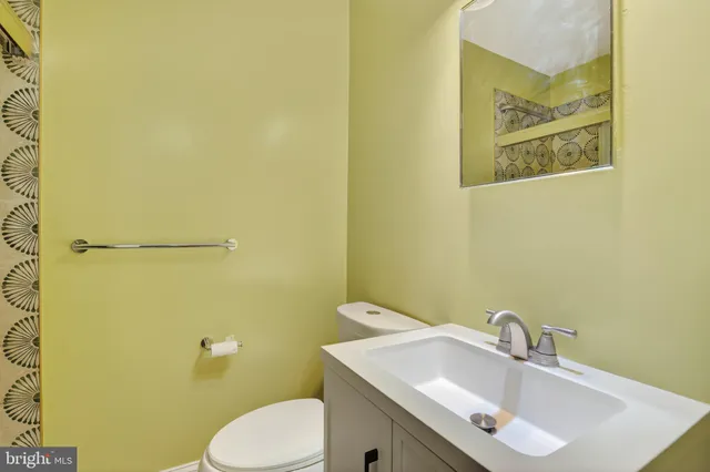 a bathroom with a sink mirror and toilet