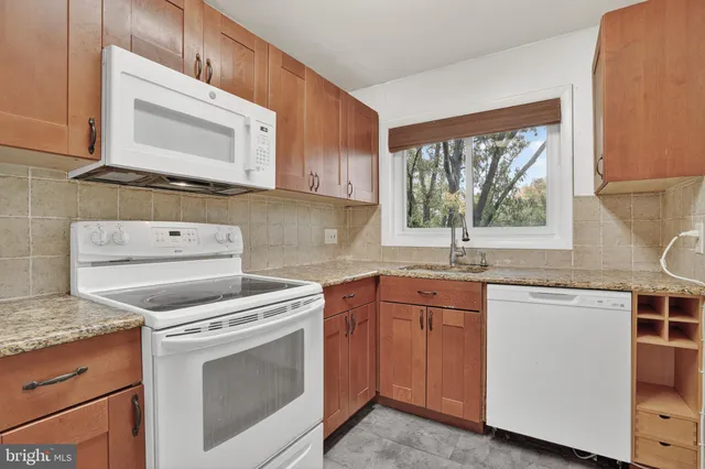 a kitchen with cabinets appliances a sink and a window