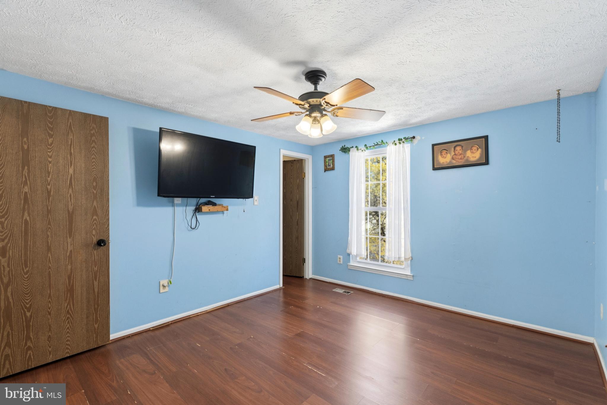 721 Rainbow Court Edgewood, MD 21040 - Photo 17 of 25 a view of a livingroom with a flat screen tv wooden floor and a ceiling fan