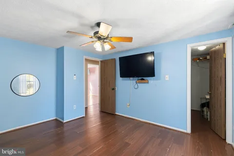 an empty room with wooden floor and mirror