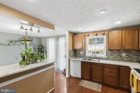 a kitchen with stainless steel appliances kitchen island granite countertop a stove a sink and a refrigerator