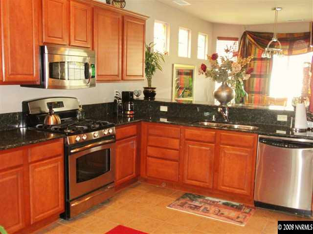 1865 Thousand Acres Way Reno, NV 89521 - Photo 3 of 6 a kitchen with stainless steel appliances granite countertop a stove a sink and a microwave