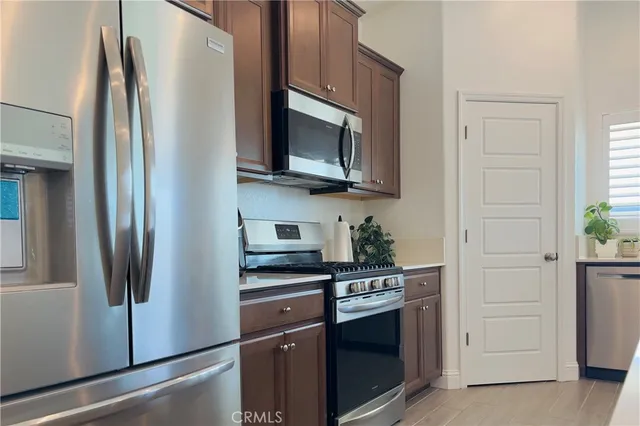 a kitchen with stainless steel appliances a refrigerator stove and microwave