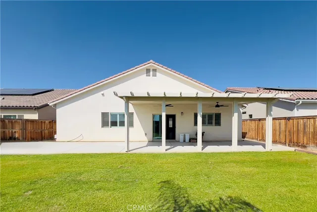 a view of a house with backyard porch and wooden fence