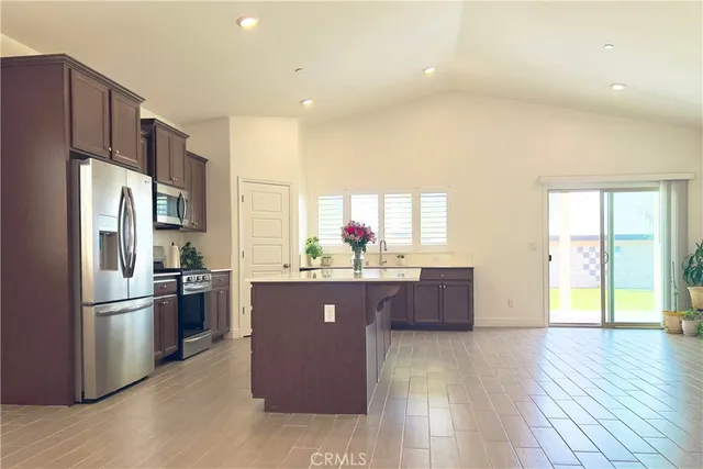 a kitchen with stainless steel appliances granite countertop a refrigerator and a stove top oven