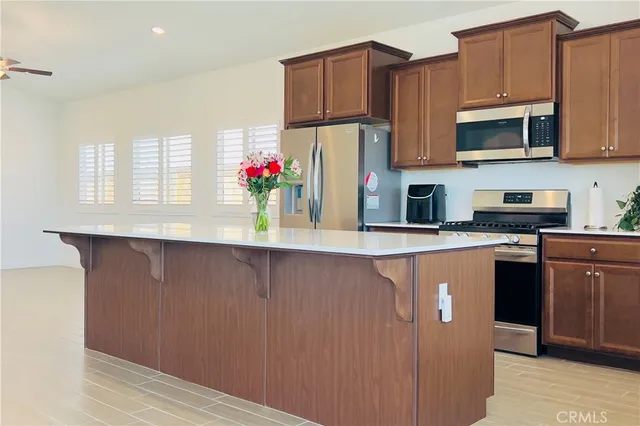 a kitchen with stainless steel appliances granite countertop a refrigerator a stove top oven a sink and dishwasher