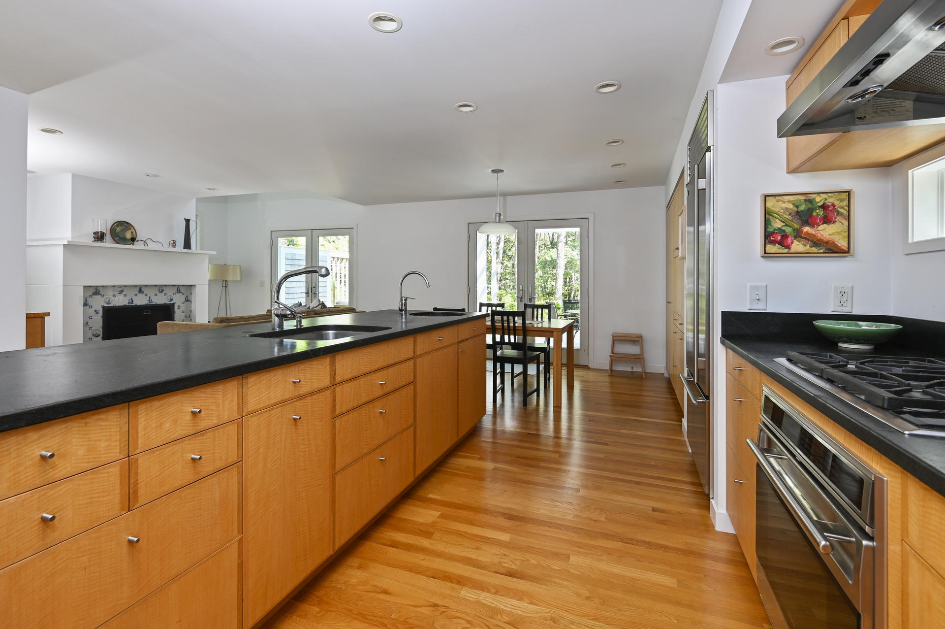 245 Cahoon Hollow Road Wellfleet, MA 02667 - Photo 16 of 36 a kitchen with stainless steel appliances granite countertop a stove top oven a sink dishwasher and cabinets with wooden floor
