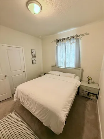 a large bed sitting in a bedroom next to a window