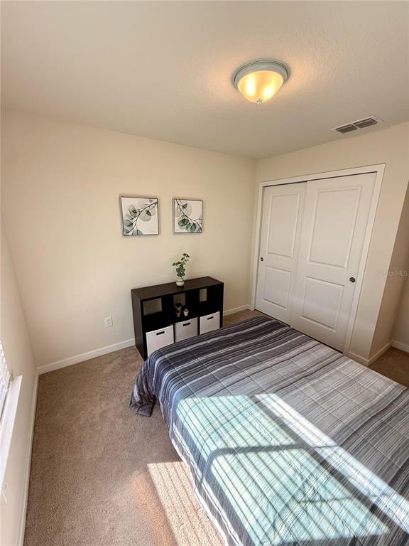 10923 Leafshore Loop Orlando, FL 32829 - Photo 18 of 44 a bedroom with a bed and a lamp