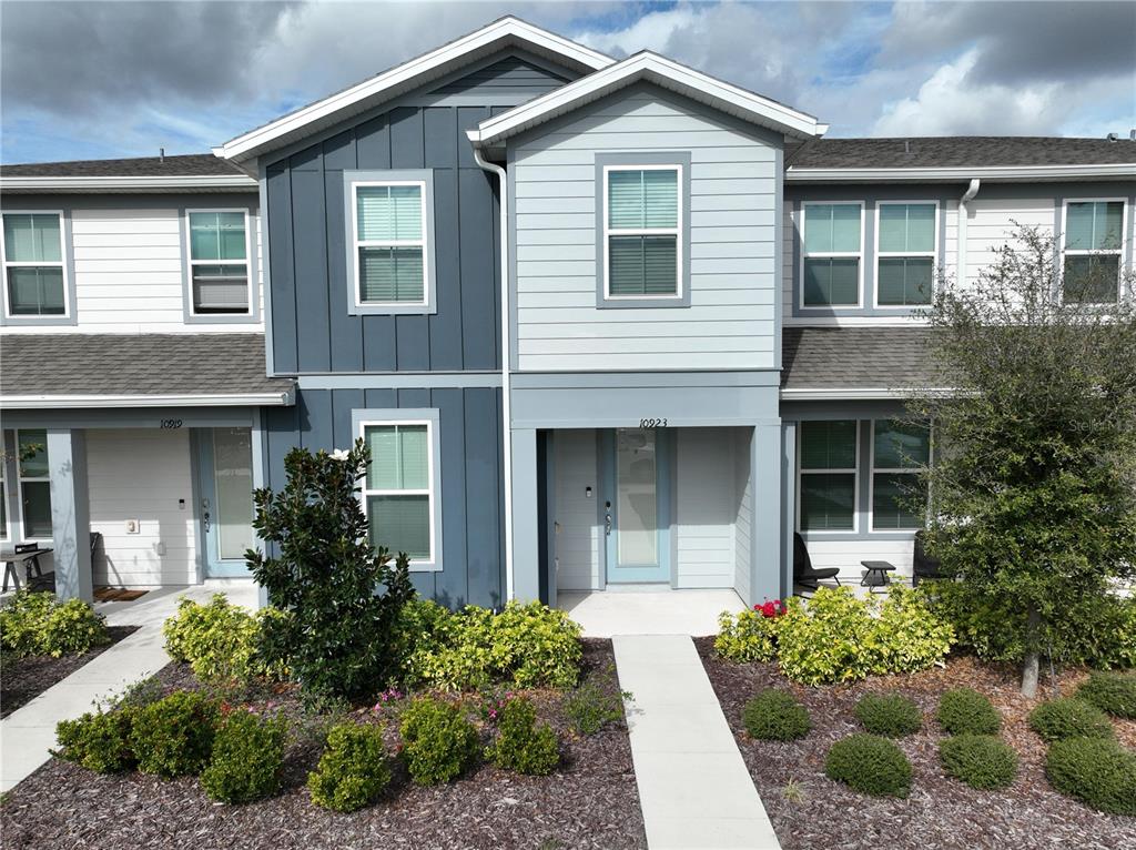 10923 Leafshore Loop Orlando, FL 32829 - Photo 2 of 44 a front view of a house with a yard and potted plants