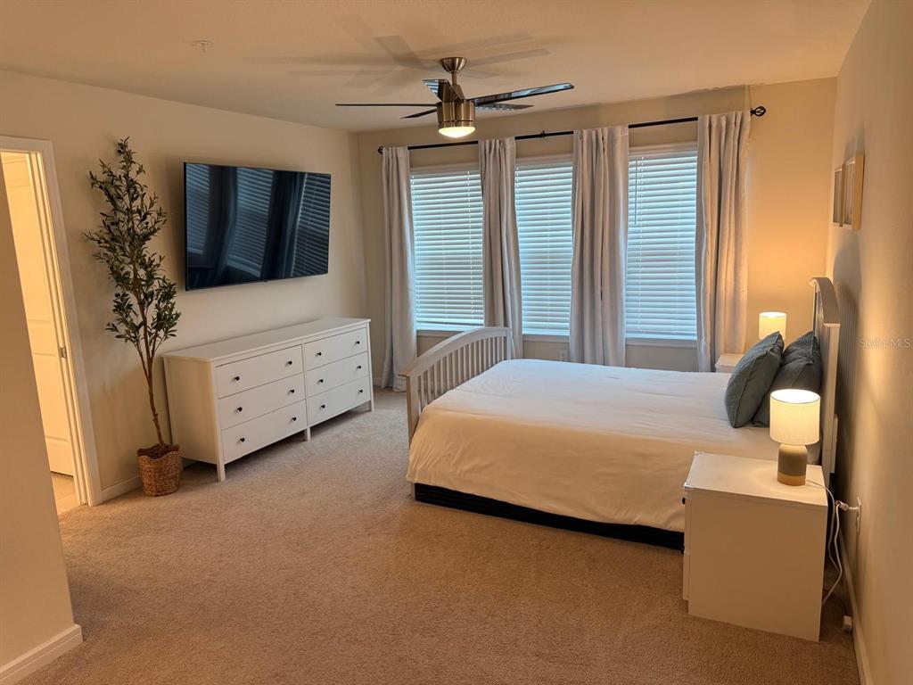 10923 Leafshore Loop Orlando, FL 32829 - Photo 29 of 44 a spacious bedroom with a bed and a flat screen tv