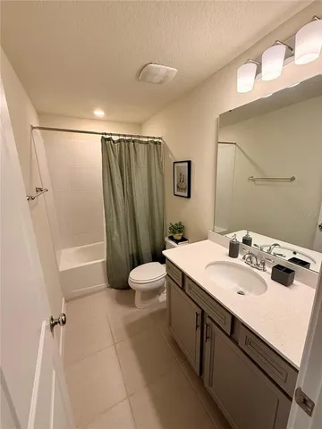 a bathroom with a sink a toilet a mirror and shower