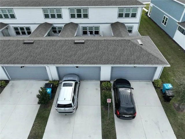 an aerial view of a house with car parked