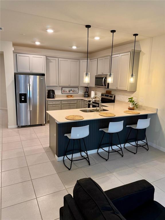 10923 Leafshore Loop Orlando, FL 32829 - Photo 5 of 44 a kitchen with stainless steel appliances a dining table chairs sink and cabinets